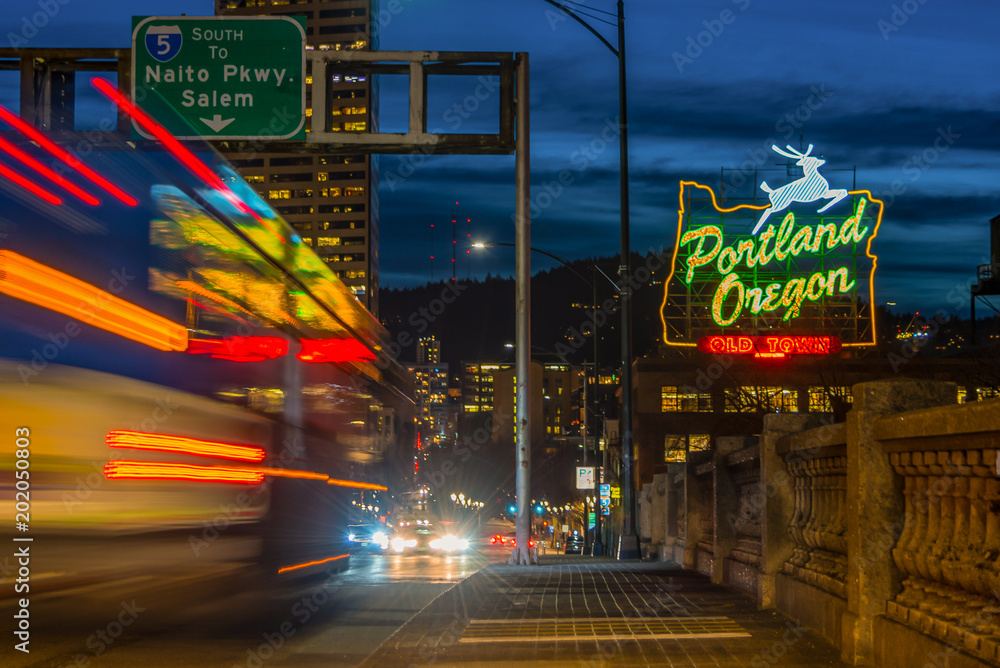 The Portland, Oregon sign lit up at night on the Burnside Bridge